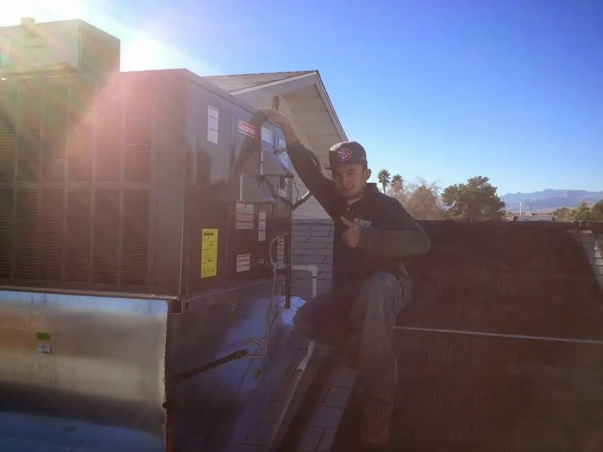 HVAC technician performing Heat Pump Repair on a rooftop unit in Castle Pines Village